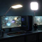 A gaming setup features dual monitors showing a fantasy-style video game, illuminated by 2 pack NEEWER L220 Bi Color Panel Lights.